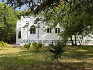 a white house with trees in front of it at Bellerive in Kilifi