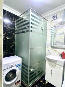 a bathroom with a washing machine and a sink at Апартамент Плаза 3 in Shymkent +11 photos