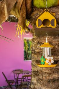 Meu Xodó Pousada في ببرانا: منزل طيور أصفر يتدلى من شجرة