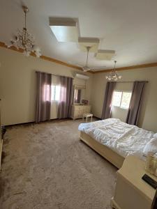 una camera da letto con un letto e un ventilatore a soffitto di شقة مدخل خاص بمدخلين a Tanomah