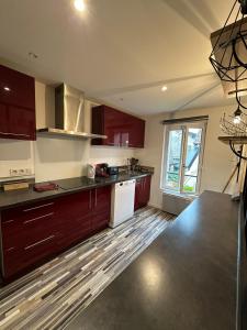 eine Küche mit dunklen Holzschränken und weißen Geräten in der Unterkunft Sweet Home in Beaumont-sur-Oise + 9 Fotos