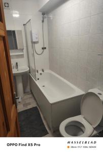 a bathroom with a tub and a toilet and a sink at Lovely 1 Bed apartment available in Croxley Green