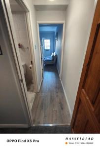 a hallway leading to a room with a blue door at Lovely 1 Bed apartment available in Croxley Green +7 photos