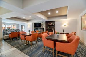 Holiday Inn Express Hotel & Suites - The Villages by IHG في ذا فيلاجيز: غرفة طعام مع كراسي برتقالية وطاولات