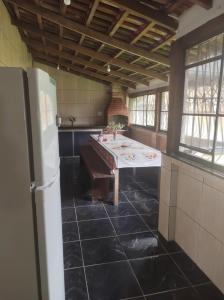 een keuken met een tafel en een koelkast bij Cantinho da Serra da Bocaina - Chalé Casal in Paraty