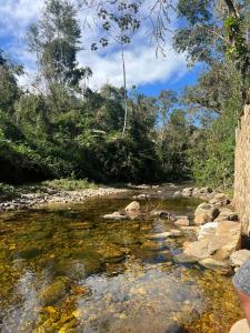 een rivier met rotsen en bomen op de achtergrond bij Cantinho da Serra da Bocaina - Chalé Casal in Paraty