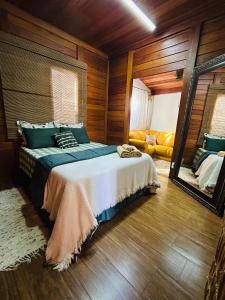 Chalé Vale da Mata - São Roque SP في ساو روكي: غرفة نوم بسرير ومرآة وأريكة +21 صورة