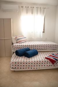 een slaapkamer met twee bedden met blauwe kussens erop bij מנוחה ומרגוע in Tiberias