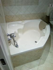 een badkuip in een badkamer met een wastafel bij מנוחה ומרגוע in Tiberias