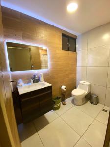 un baño con lavabo e inodoro en Cozy house 5 minutes from the airport, en Las Flores