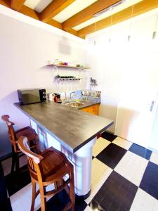 eine Küche mit einer Theke und zwei Holzstühlen in der Unterkunft L'Andalouse in Vailly-sur-Sauldre + 17 Fotos