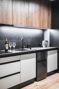 a kitchen with a sink and two wine glasses at Apart Studio Śródmieście in Gdańsk