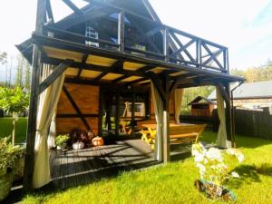 a house with a blue roof in a yard at Leśny Sentyment na Gwizdówce na Kaszubach in Załakowo