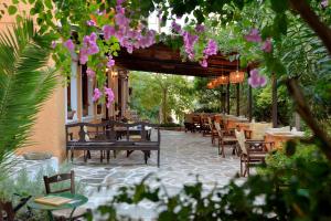 ein Restaurant mit Tischen und Stühlen und rosa Blumen in der Unterkunft Vagia Traditional, Aegina Island in Vaia