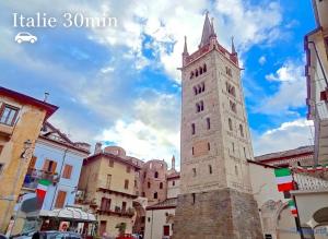 a tall building with a clock tower in a city at Appartement au cœur de la Vallée de la Maurienne in Saint-Julien-Mont-denis +7 photos