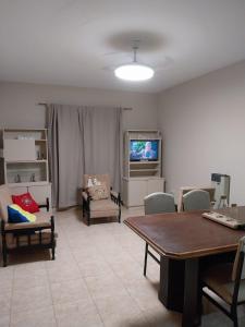El retamo - Casa Turística في سان رافاييل: غرفة معيشة مع تلفزيون وطاولة وكراسي +6 صور