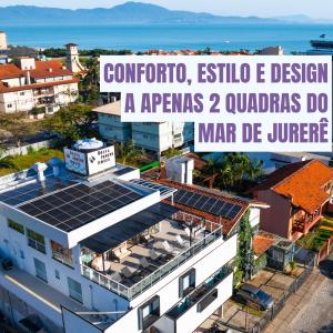 uma vista aérea de um edifício com painéis solares no telhado em Bossa Jurerê Hotel em Florianópolis