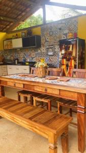 a large wooden table with benches in a kitchen at Sítio recanto do Saltinho Santa teresa -ES in Santa Teresa
