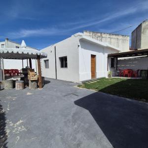 un edificio blanco con patio y mesa en Casa en el centro de Piriapolis a 1 cuadra de la playa, en Piriápolis