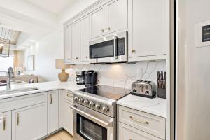 uma cozinha com armários brancos, um fogão e micro-ondas em HP 42W Peaceful Nest by 30A Escapes em Rosemary Beach