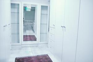a white bathroom with white cabinets and a mirror at WINDHOEK ODYSSEY House in Windhoek +7 photos
