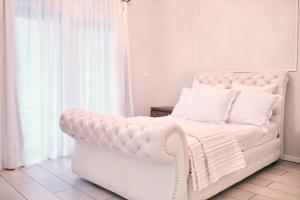 a white bed and a white couch in a room at WINDHOEK ODYSSEY House in Windhoek