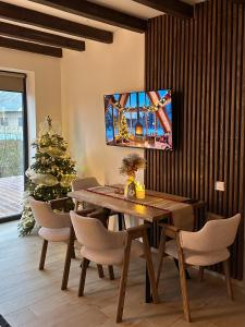a dining room with a table and a christmas tree at Domivka котедж із чаном-джакузі, каміном і кіно-зоною у Cлавську in Slavske