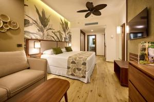 科克Riu Guanacaste - All Inclusive的一间酒店房间，里面有一张床和一张沙发
