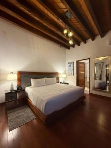 een slaapkamer met een groot bed en een grote spiegel bij Mirtala Hotel Boutique in Guanajuato