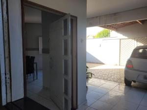 een deur naar een huis met een auto buiten geparkeerd bij Suítes Privativas - Casa Compartilhada in São Raimundo Nonato