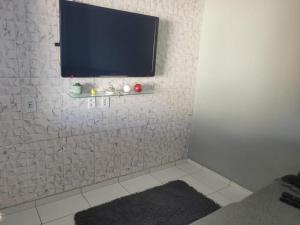 een badkamer met een televisie op een witte muur bij Suítes Privativas - Casa Compartilhada in São Raimundo Nonato