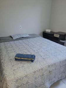 een bed met een blauwe deken erop bij Suítes Privativas - Casa Compartilhada in São Raimundo Nonato