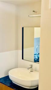 a bathroom with a white sink and a mirror at BOHO Living Kochi Airport in Cochin