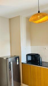 a kitchen with a microwave and a refrigerator at BOHO Living Kochi Airport in Cochin +9 photos