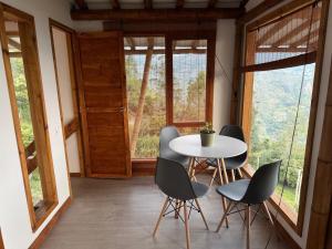 een tafel en stoelen in een kamer met ramen bij Cabaña montaña Choachi in Choachí +21 foto's