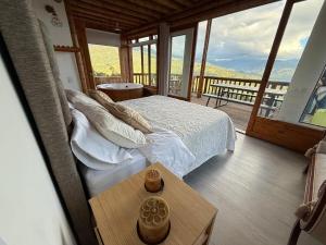 een slaapkamer met een bed en een tafel en een balkon bij Cabaña montaña Choachi in Choachí