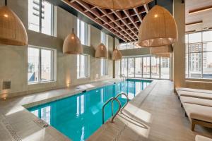 einen Pool in einem Gebäude mit Fenstern in der Unterkunft Panoramic Horizon Condo - Downtown Montreal with Pool and Parking in Montreal