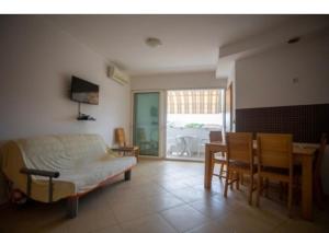 een woonkamer met een bed, een tafel en stoelen bij Lucia&Laura in Turanj