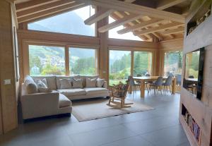 a living room with a couch and a table at Chalet Taulei tra Bormio e Livigno in Valdidentro