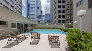 a patio with chairs and a swimming pool on a building at St Charbel by Charlie in São Paulo