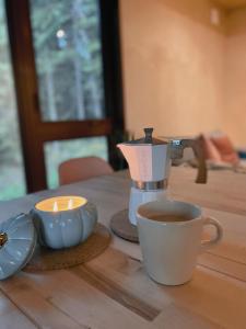 a cup of coffee and a candle on a table at Micro-cabine, Méandre, La Tuque in La Tuque
