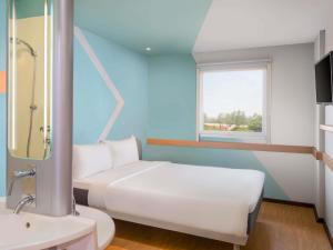 a bedroom with a white bed and a sink at Ibis Budget Jakarta Airport in Tangerang +22 photos