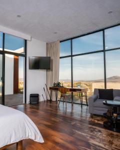 Casa Diamante Hotel Boutique - Mineral de Pozos في Mineral de Pozos: غرفة نوم بها سرير وأريكة وطاولة