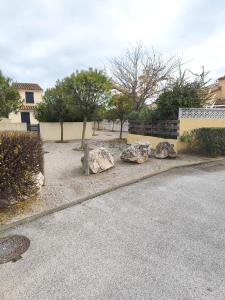 a yard with rocks and trees and a building at Chez David in La Celle-sous-Gouzon
