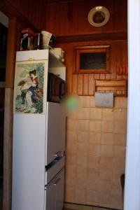 a kitchen with a refrigerator with a painting on it at Chez David in La Celle-sous-Gouzon +13 photos