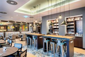 Un restaurante con mesas y sillas y un bar. en Premier Inn Düsseldorf City Friedrichstadt, en Düsseldorf