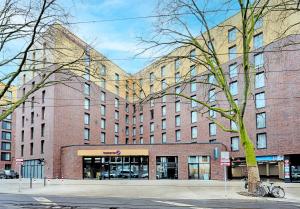 un gran edificio de ladrillo en una calle de la ciudad en Premier Inn Düsseldorf City Friedrichstadt, en Düsseldorf