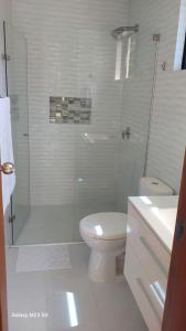 um banheiro branco com chuveiro e vaso sanitário em Paraiso Escondido Guachaca em Guachaca