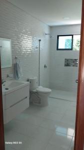 um banheiro branco com vaso sanitário e chuveiro em Paraiso Escondido Guachaca em Guachaca