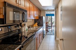 Relaxing Oceanfront Condo - Holiday Pavilion 211 في ميرتل بيتش: مطبخ مع حوض وموقد الفرن العلوي